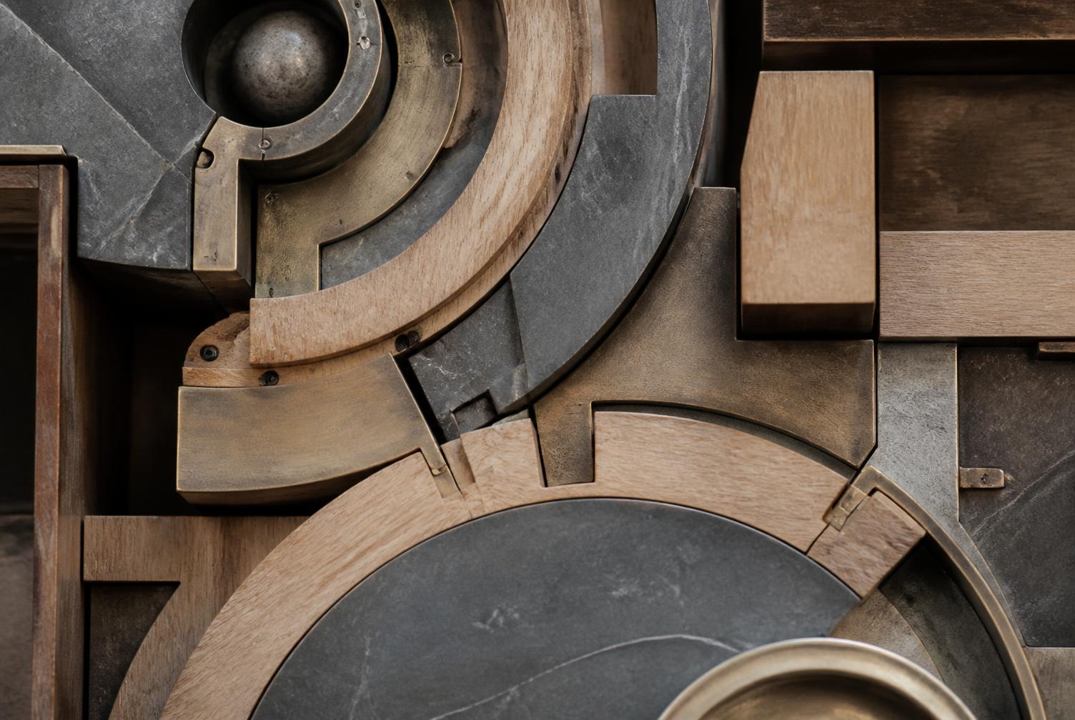 Overhead macro view of interlocking timber, stone and brushed metal components, one hidden junction becoming visible